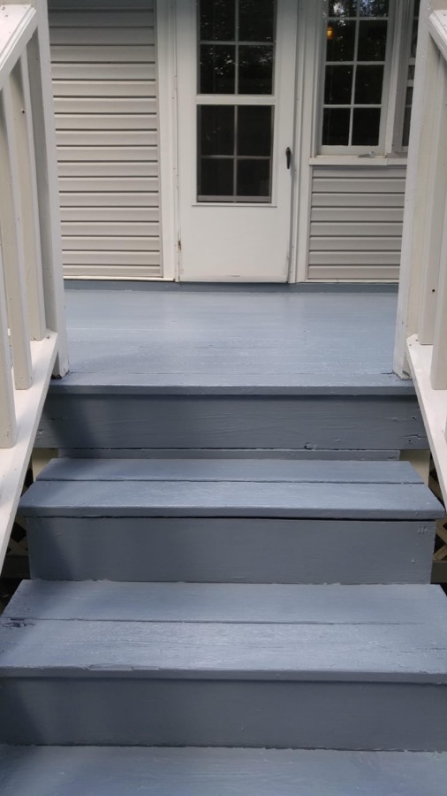 Freshly painted blue-gray back porch steps and deck