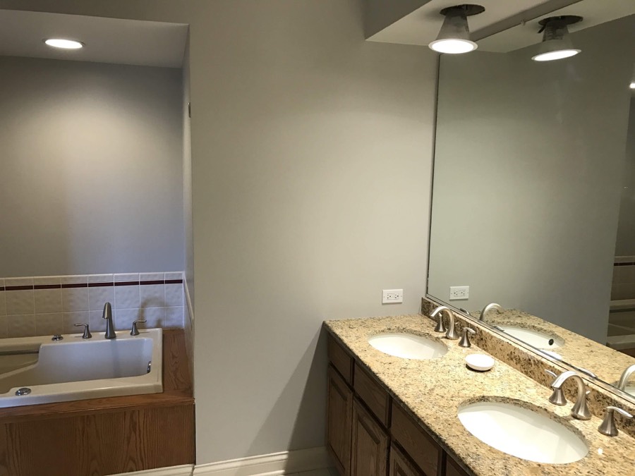 Repainted primary bathroom with double vanity and soaking tub