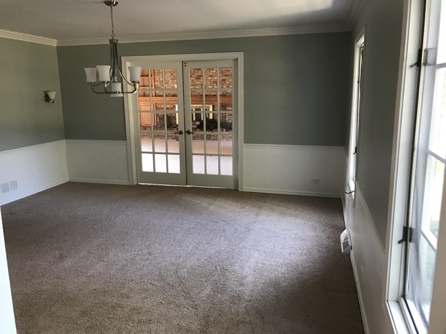 Dining room with sage green walls, white wainscoting, and French doors