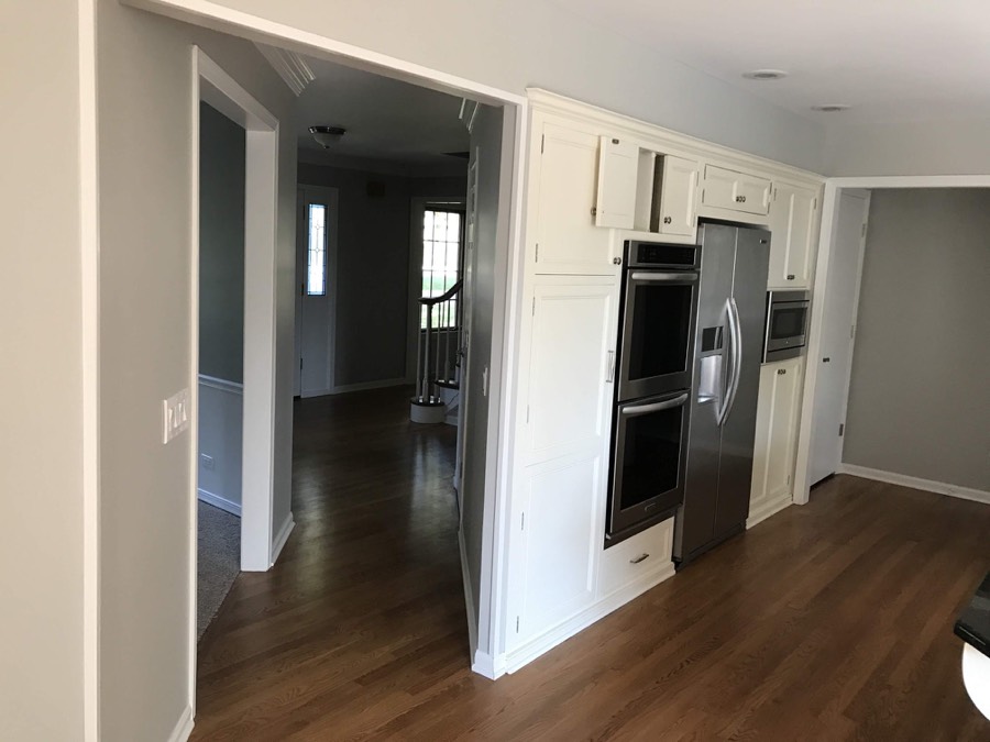 Repainted kitchen and hallway with white cabinets and stainless appliances